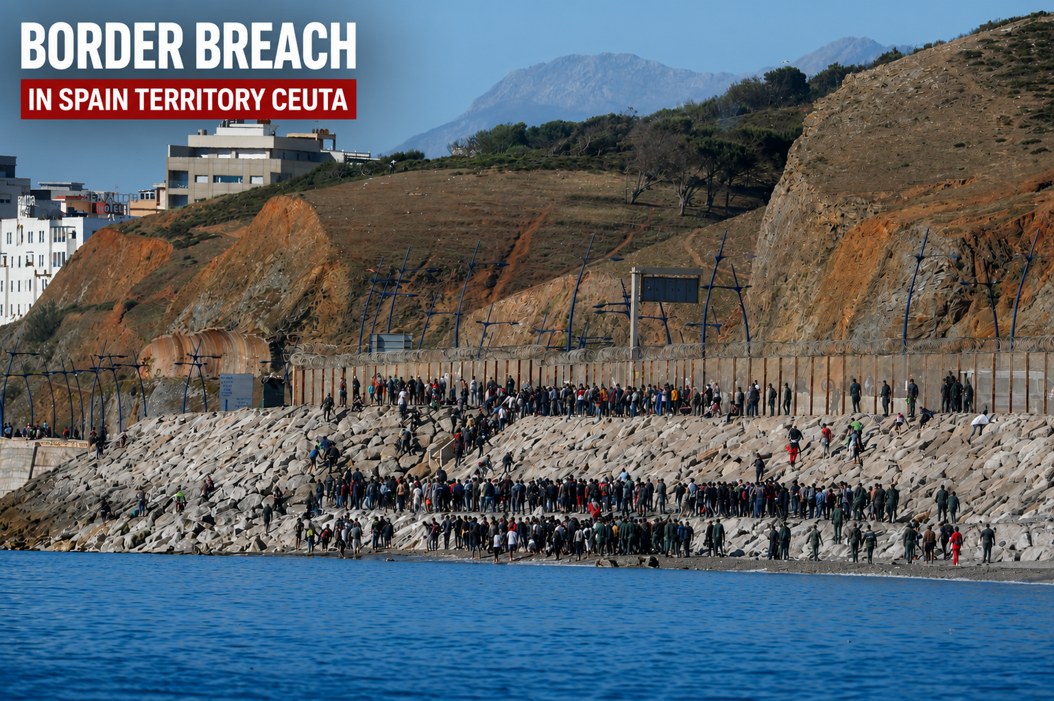 Migrants gather near the border fence in Ceuta after crossing from Morocco into Spanish territory